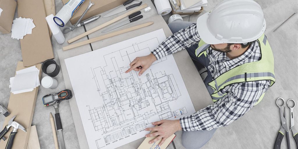 Contractor reviewing plans at a construction site.